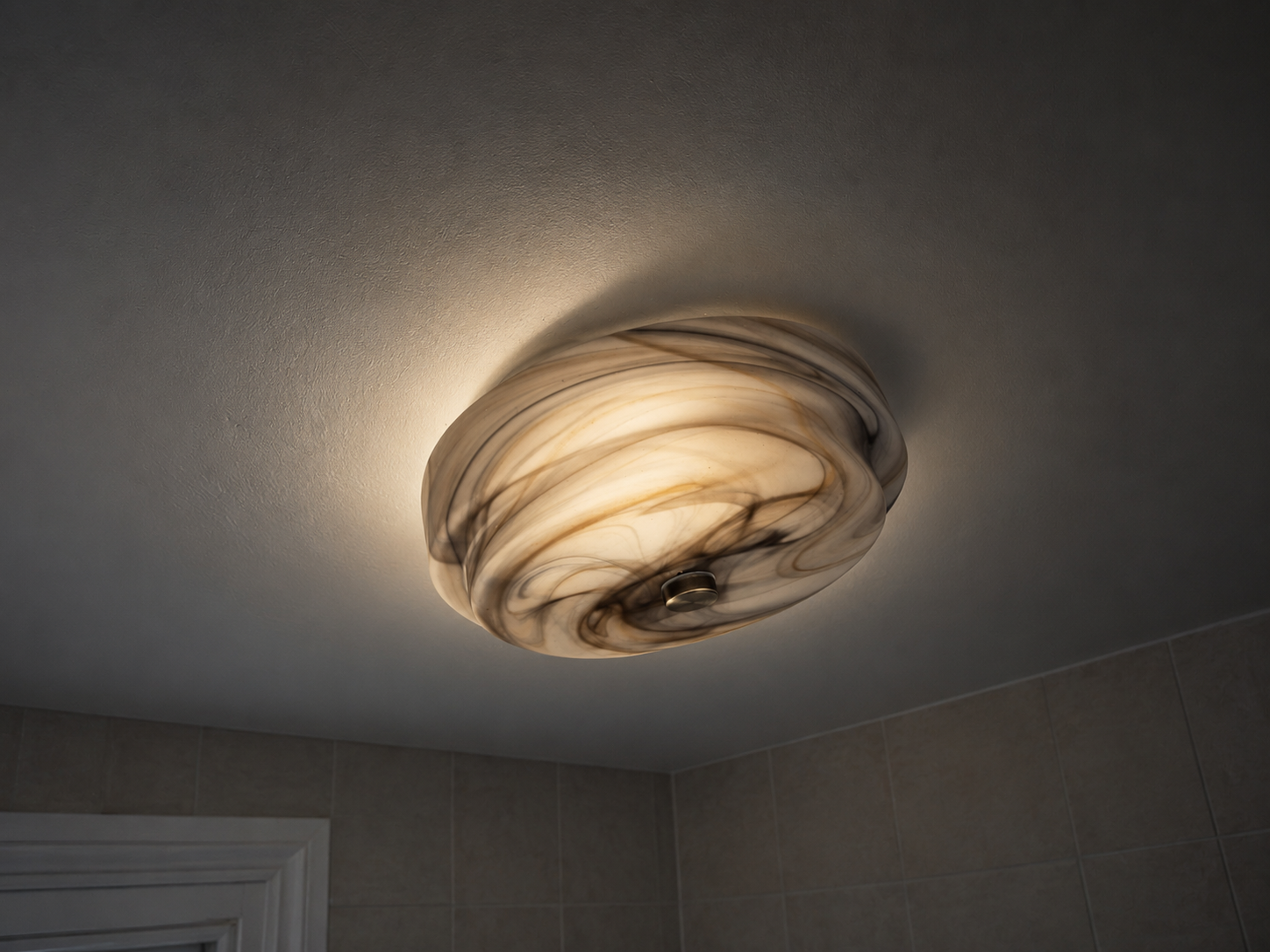Illuminated flush ceiling light fitting in a tiled bathroom