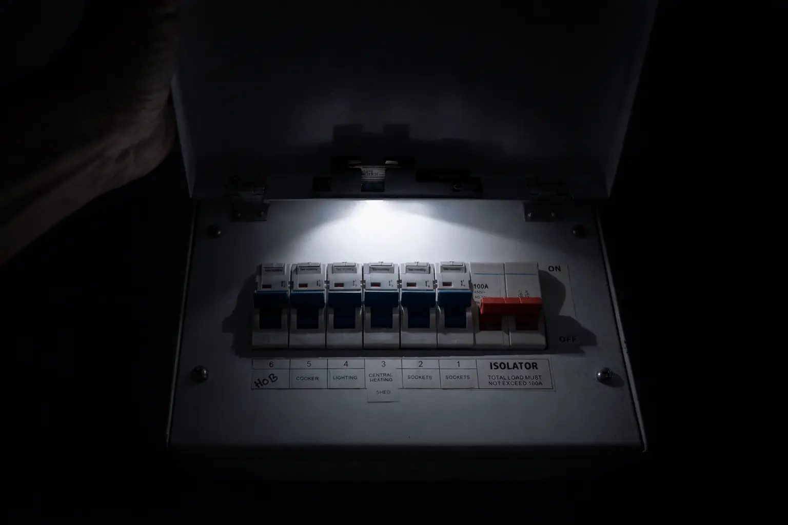 Consumer unit inspected by torchlight during an evening power cut